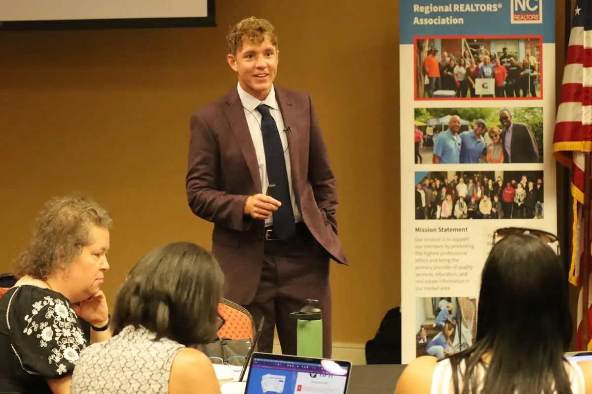 Travis Old teaching an RPR session to a room of agents working on laptops